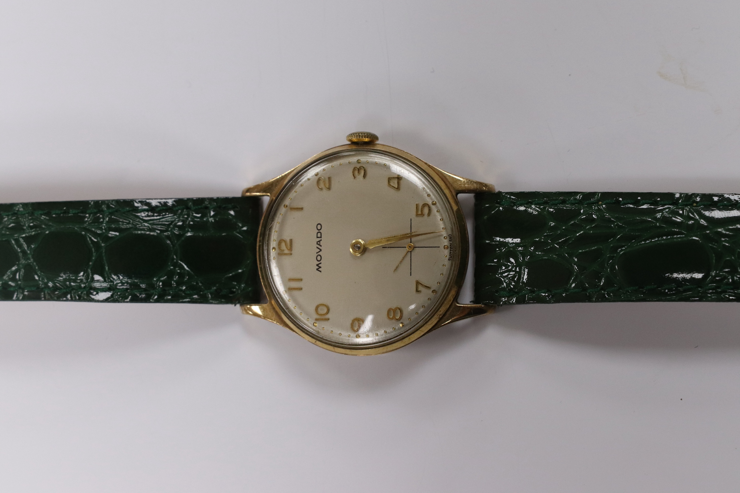 A gentleman's 1950's 9ct gold Movado manual wind wrist watch, with Arabic dial, subsidiary seconds and case back inscription, case diameter 31mm, on a later associated leather strap. Condition - fair